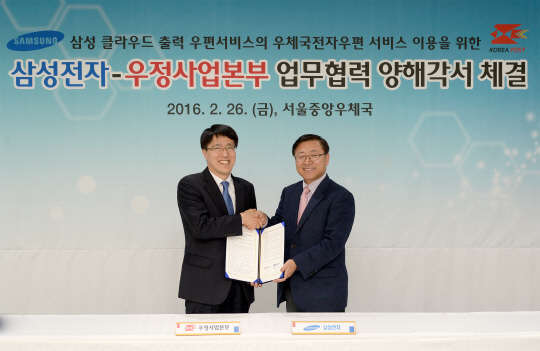 지난 26일 서울중앙우체국에서 (왼쪽부터)박종석 우정사업본부 우편사업단장과 송성원 삼성전자 프린팅솔루션 사업부 전무가 클라우드 프린팅 서비스의 전자우편 연계를 위한 업무협력 양해각서를 체결하고 있다. <삼성전자 제공>